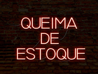 Clearance Sale (in portuguese) red neon sign. Background texture of rustic brick wall old red orange