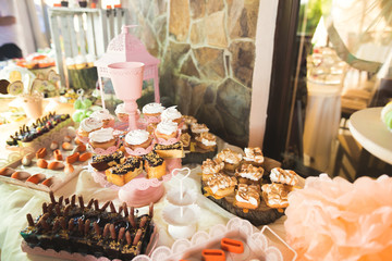 Delicious sweets on wedding candy buffet with desserts, cupcakes
