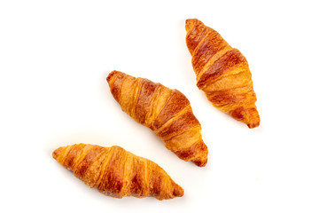 An overhead photo of three croissants, shot from above on a white background with copy space
