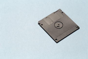 Black floppy disk on light gray background close up