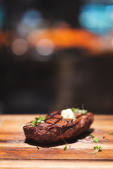 piece of beef steak on wooden plate with bokeh background