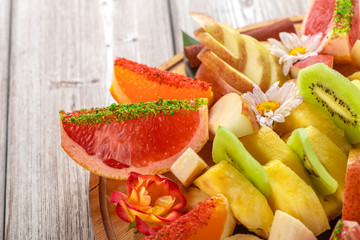 Fresh fruits in plate on wooden table