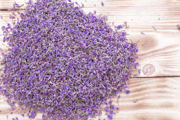 lavender dried scattered flowers on wooden background, top view