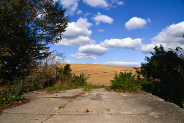 big white clouds in a blue sky above field