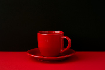 Tea on a black and red background for design. A red cup of tea on a black background creates a...