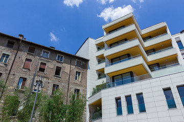 Fototapeta premium New tall apartment house build near a small and old apartment