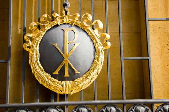 Beautiful entrance of a cemetery with Chi Roh symbol of a P and X, that is a form of christogram and represents the Christian belief.