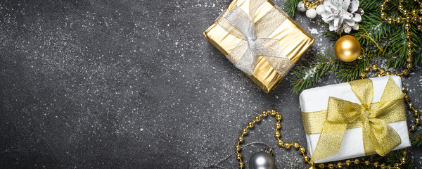 Christmas background with gold and silver decorations on black.