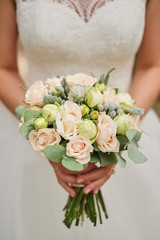 Bride holding a wedding bouquet in pastel pink colors. closeup.