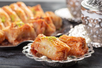 Turkish arabic dessert baklava with honey and nuts on a silver plate