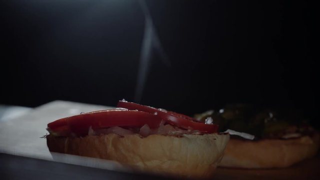 Chef preparing the burger, frying the bun on the grill, adding salt