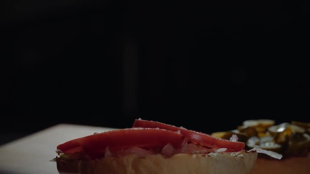 Chef preparing the burger, frying the bun on the grill, adding pepper