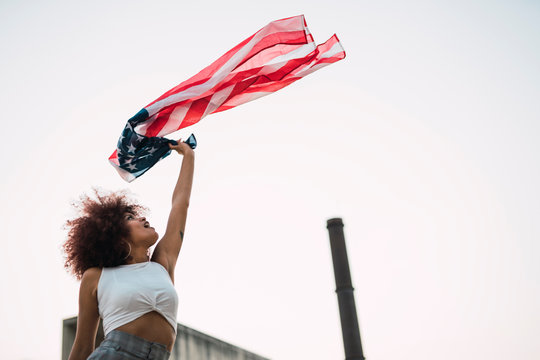Young woman waving American flag