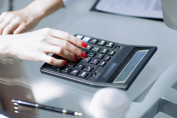 .closeup.business woman using a calculator at the workplace.