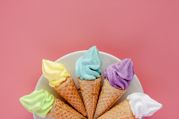 White plate of various of ice cream cone on pink background for sweet and refreshing dessert concept