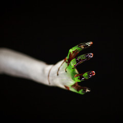 creepy halloween hand in green and white with blood, zombie hand on black background