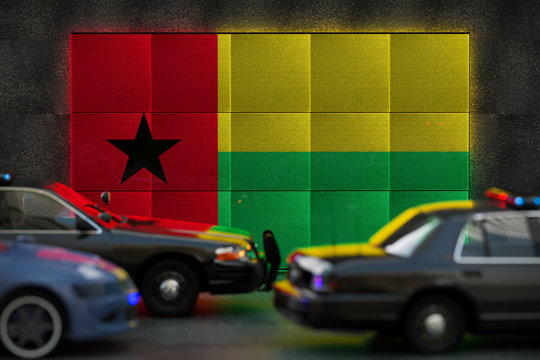 Bright digital display Guinea Bissau flag in city as cars drive past - Powered by Adobe