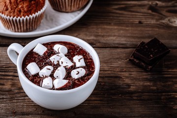 A cup of hot chocolate or cocoa with marshmallows on wooden background