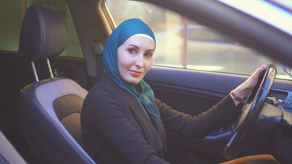 portrait of a muslim woman driving a car