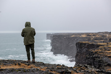 Man Standing by the Cliff in a Storm