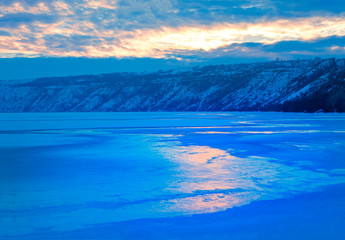 Fototapeta na wymiar winter nature with sunset reflection in frozen lake 