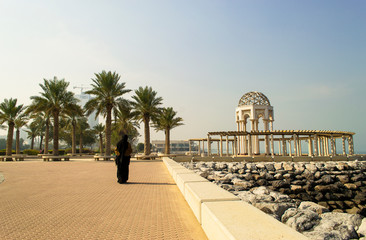 Woman Walking On Sunny Cliff In Kuwait City. View From Kuwait