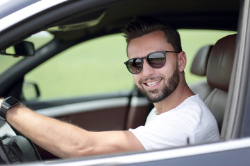 stylish young man driving a convertible car
