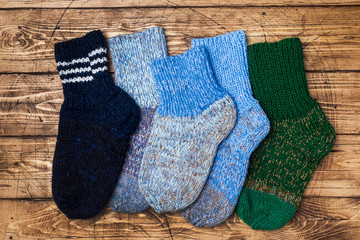Obraz na płótnie Canvas Warm wool knitted socks for cold winter on wooden background.