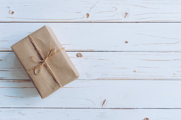 Fototapeta premium Above brown gift box on wooden table background with copy space.