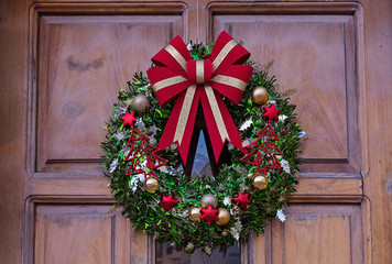 Traditional Christmas fir wreath with red ribbon, Christmas balls and bells. Decoration of the...