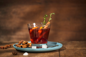 Autumnal concept with cup of tea with lemon, cinnamon stick and anise star on rustic wooden background