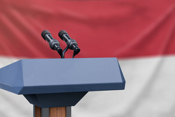 Podium lectern with two microphones and Indonesia flag in background
