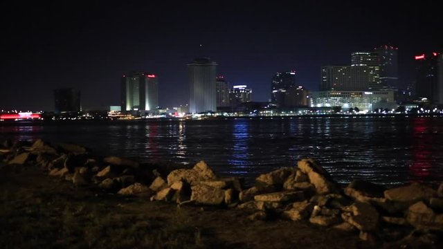 Pan of New Orleans skyline at night time from West Bank levy