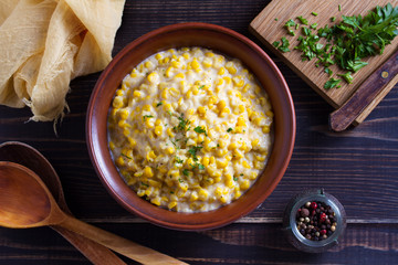 Sweet and creamy skillet corn. Homemade corn dish. View from above, top studio shot