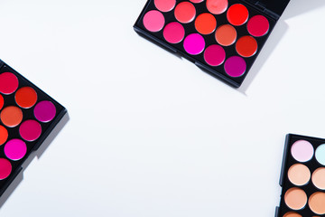 Various lipstick and eye concealer palettes with lots of colors isolated on white background....
