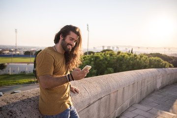 young man with long hair using his mobile phone
