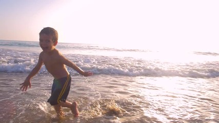 Slow motion - Two little brothers running, playing and enjoying while the camera chase them smiling and laughing