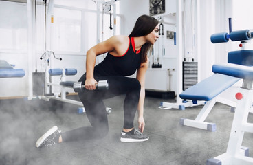 The girl does exercise in the gym