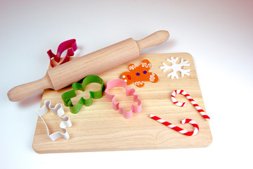 Wooden rolling pin and cutting board, cookie cutters, gingerbread man. Christmas and New Year holiday background concept. Copy space for text.