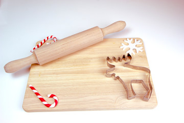 Wooden rolling pin and cutting board, cookie cutters, gingerbread man. Christmas and New Year holiday background concept. Copy space for text.