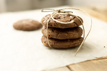 Homemade tower of chocolate chip cookies on the parchment paper tied with string, one cookie on a side