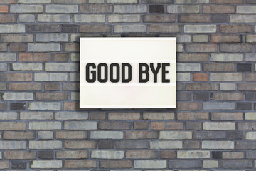 Good bye in light box on brick wall