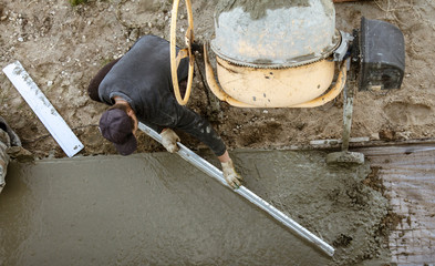 Workers pour concrete solution at a construction site