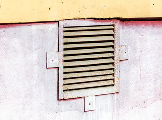 Ventilation grille hanging on the wall of a building