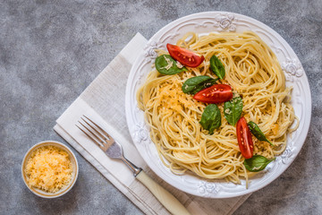 meat balls with spaghetti pasta with fresh spinach, tomatoes and cheese on a white plate