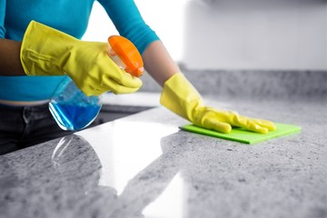 Mid section of woman cleaning kitchen counter