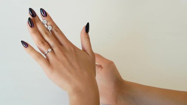 Woman looking at the earrings with diamonds at her hands in the jewelry shop. lady trying on some jewel at the boutique.