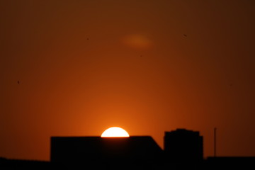 Fototapeta na wymiar Peaceful silhouette sunset behind a small building