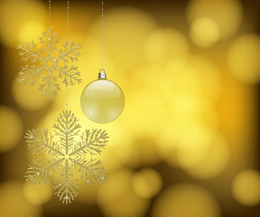 Christmas design with golden glitter snowflake ornaments and a bauble and space for text on golden bokeh background.