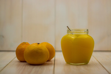 organic orange juice in a glass mason jar on wooden background